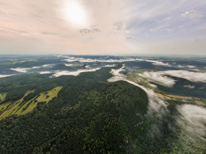 Ein Luftbild mit Wolken und viel Wald