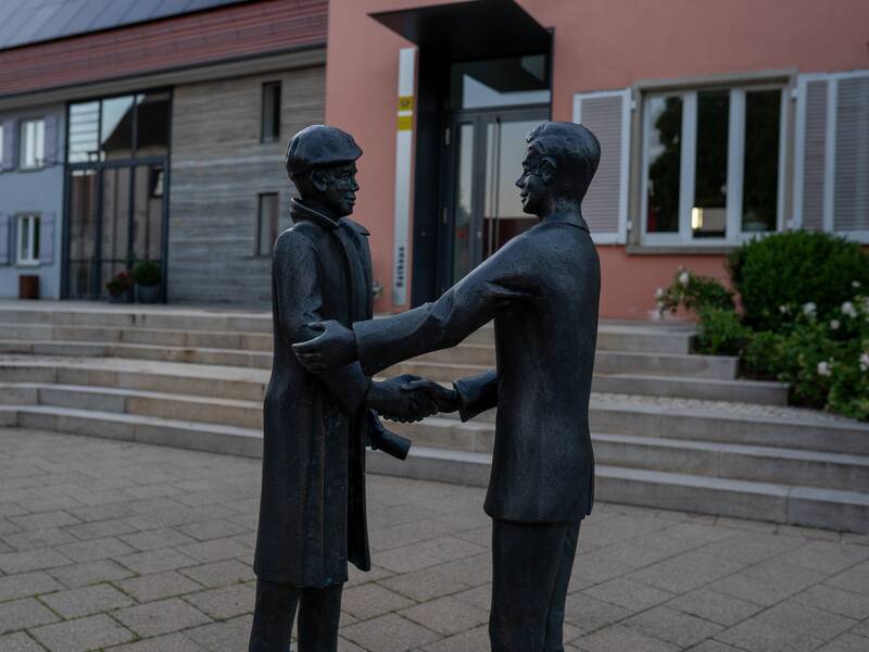 Die zwei Statuen geben sich die Hand