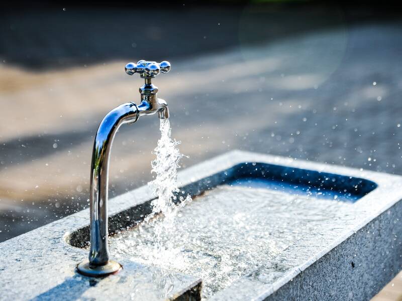 Wasser sprudelt in einen Trinkbrunnen